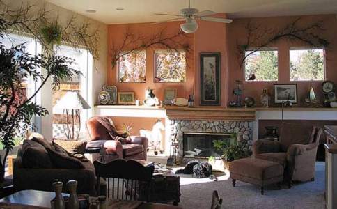 Iron Pine Branches adorn the Windows with Persimmon Colored Wall, Faux Painted Mantel and accents of color added to the Stone Fireplace and Hearth.